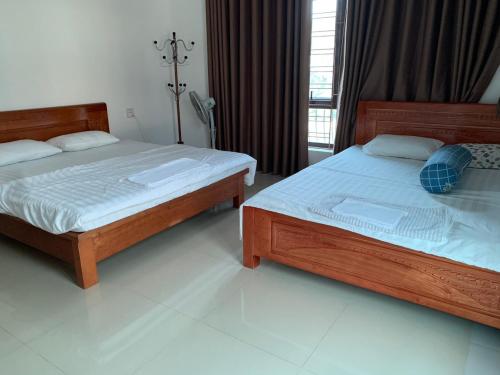 two beds in a hotel room withthritisthritislictslictslicts at 502 Sân Bay Điện Biên in Diện Biên Phủ