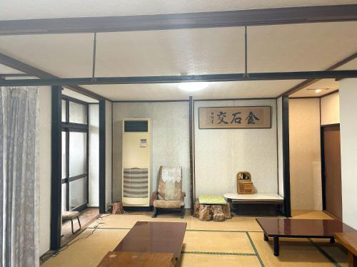 a living room with a chair and a table at エコホテル　湯の児荘 in Minamata