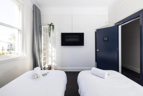 um quarto de hotel com duas camas e uma televisão em The Albion Hotel em Wickham