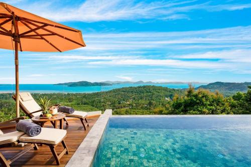 an infinity pool with an umbrella and chairs and a table at Villa Bella Vista Samui - 360 Degrees Mountain View in Taling Ngam Beach