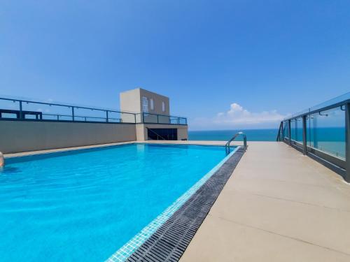 una piscina en la azotea de un edificio con el océano en Sea Wave Luxuy Apartment, en Negombo