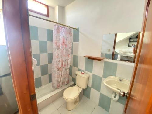a bathroom with a toilet and a sink at Ballesteros Apartaments in Puerto Ayora