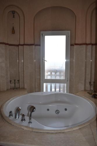 baño con bañera grande y ventana en Marina Agadir Royal Apartment, en Agadir
