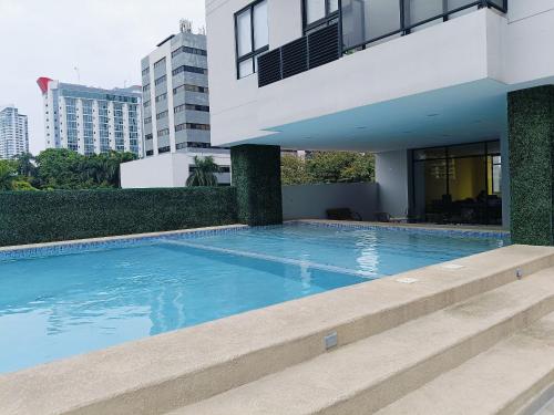 a swimming pool in front of a house at Hermoso Apartamento ven de trabajo o turismo te va a encantar in Panama City