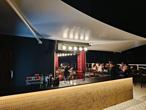 a restaurant with a bar with people in the kitchen at Hermoso Apartamento ven de trabajo o turismo te va a encantar in Panama City