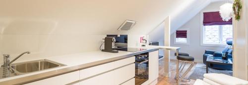 a kitchen with a counter with a sink and a chair at Boe Apartment Hotel in Egersund