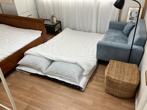 a bedroom with a bed and a couch and a chair at The Sheem Moraenae Market St 10min in Incheon