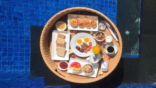 een bovenaanzicht van een bord met eten naast een zwembad bij Vamana Resort - CHSE Certified in Gili Trawangan