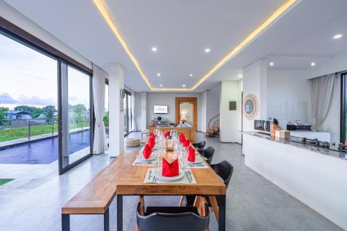 a dining room with a long table and chairs at Villa Emilia Seminyak by Nagisa Bali in Kerobokan