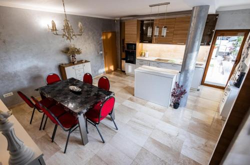 蒂米什瓦拉的住宿－RED，厨房以及带桌子和红色椅子的用餐室。