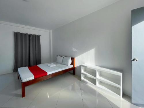 a small bedroom with a bed and a window at RedDoorz At Fat J Apartelle Mactan in Cebu City
