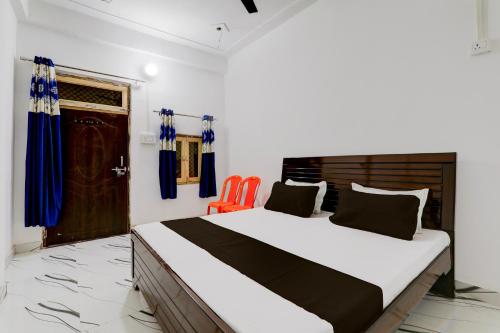 1 dormitorio con 1 cama y 2 sillas de color naranja en OYO RD PALACE, en Auraiya