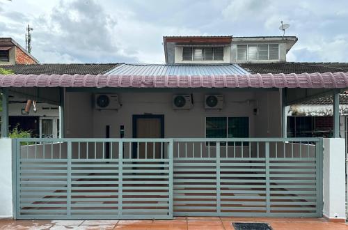 a house with a white fence in front of it at Stylish HomeStay Near JonkerWalk in Melaka