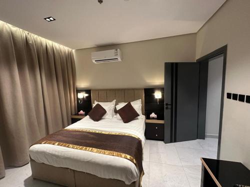 a bedroom with a large bed in a room at شقق المجرات الذهبية المخدومة in Al Baha