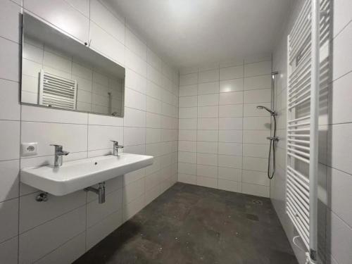 a white bathroom with a sink and a mirror at Calvarie-studio in Maastricht