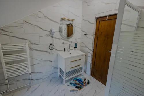 a white bathroom with a sink and a mirror at TEXAS in Timişoara