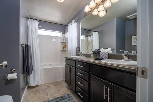 y baño con lavabo, bañera y espejo. en Elegance: Your Urban Retreat in Salt Lake City, en South Salt Lake