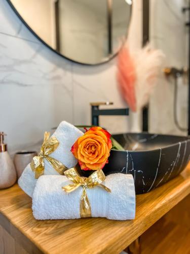 a flower in a bowl on a counter with a mirror at Deluxe Room 33 in Bled