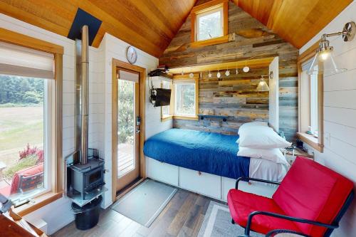 a bedroom with a bed in a tiny house at Sandbug - tiny home tranquility on the Oregon Coast! in Waldport