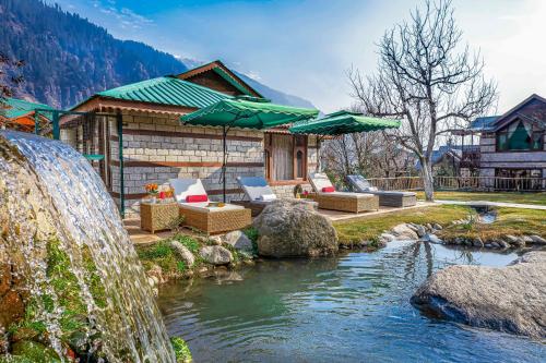 a house with a waterfall next to a river at Storii By ITC Hotels Urvashis Retreat, Manali in Manāli