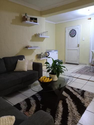 a living room with a couch and a table at Olivia Pines Guesthouse 4 Bedroom Self Catering House in Krugersdorp