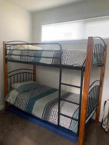 two bunk beds in a room with a window at Tranquil Getaway Wifi Netflix Pet friendly in Venus Bay