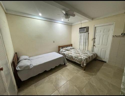 a bedroom with two beds and a ceiling fan at Casa la Picola in Sierpe