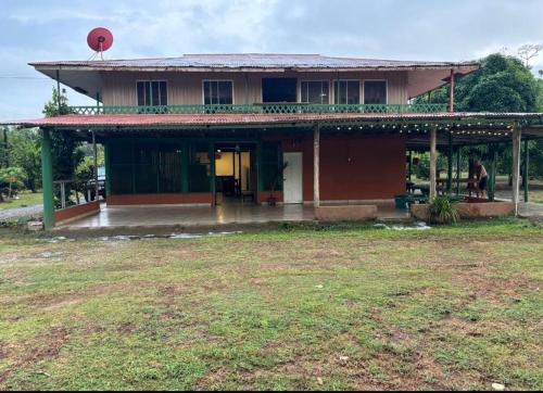 a house with a large yard in front of it at Casa la Picola in Sierpe