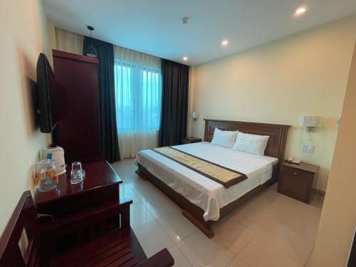 - une chambre avec un lit, un bureau et une télévision dans l'établissement Thanh Phúc Hotel, à Dong Hoi