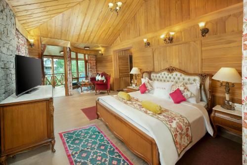 a bedroom with a large bed and a television at Storii By ITC Hotels Urvashis Retreat, Manali in Manāli