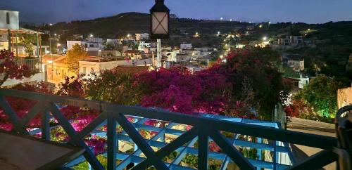 a view of a city at night from a balcony at Xenonas in Kamilari