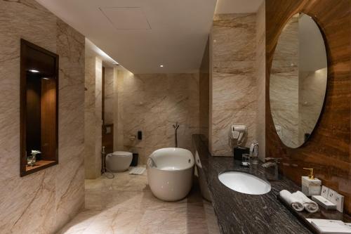 baño con 2 lavabos y espejo grande en Swiss-Belhotel Harbour Bay en Nagoya