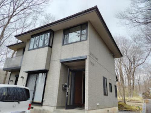 ein Haus mit einem davor geparkten Auto in der Unterkunft スターリースカイズ那須店 in Nasu