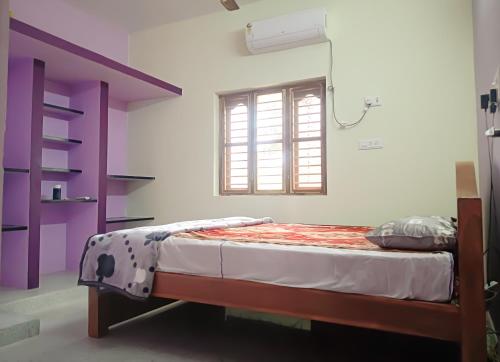 a bed in a room with a window at NAKSHATHRA Guest House 2BHK in Tiruvannāmalai