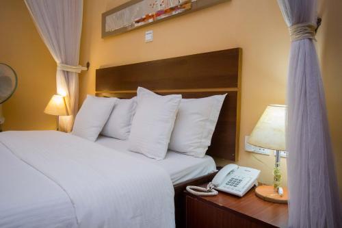 a hotel room with a bed and a telephone at Capital Heights Hotel in Nairobi