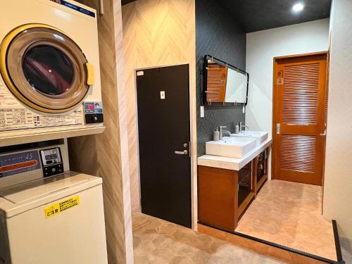 un bagno con lavandino e lavatrice di ゲストハウス JOOOY Hotel 奄美 ad Amami