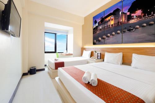 Una cama o camas en una habitación de Pandanaran Prawirotaman Yogyakarta