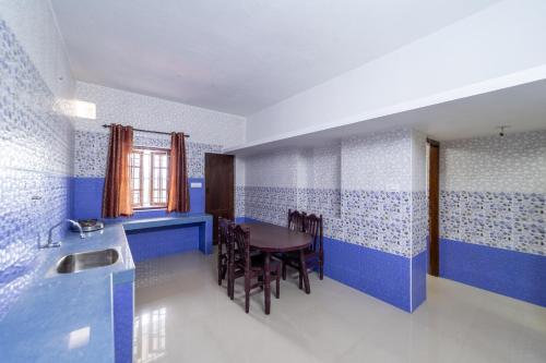 a dining room with blue and white walls and a table at Sri Nandha Luxury Comforts in Vālpārai