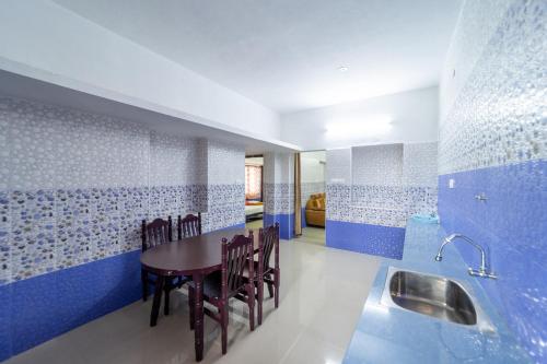 a dining room with blue and white walls and a table and chairs at Sri Nandha Luxury Comforts in Vālpārai