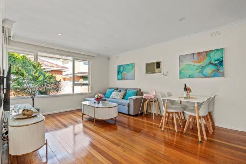 a living room with a couch and a table at StayAU 2BRM Beach Family House Hampton in Melbourne