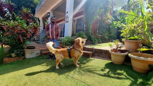 a man and his dog in front of a house at The SKYi County Dapoli in Dapoli