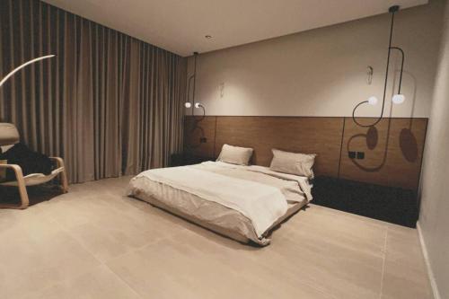 a bedroom with a bed and a chair in it at Jriska apartment in Riyadh