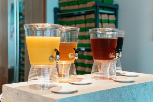 four glasses of different colored drinks sitting on a table at THE SENAGAJIMA STORYLINE in Tomigusuku