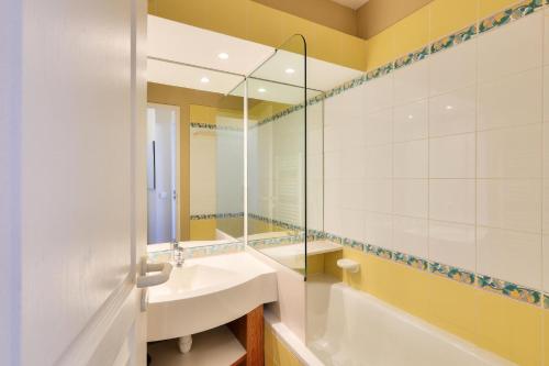une salle de bain avec un lavabo, une baignoire et un miroir dans l'établissement Résidence Quartier Falaise - maeva Home - 2 pièces 4 pers Confort MAE-5168, à Avoriaz