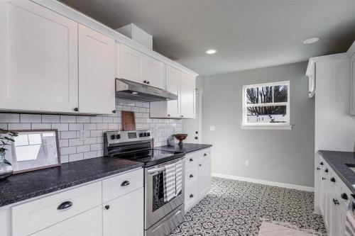 uma cozinha com armários brancos e um forno com placa de fogão em Entire home 3B/3B 2356 sq.ft em Everett
