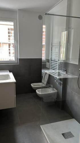 a bathroom with a sink and a toilet and a mirror at Casa Canova - private room in sharing apartment in Trento