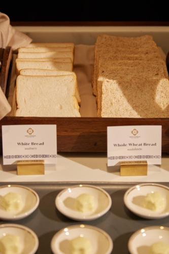 a display case with sandwiches and bread on display at CHINO@NIMMAN Luxury Boutique Hotel in Chiang Mai