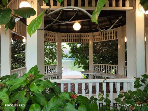 a front porch of a house with windows at Cottage by the pond in Ban Thung Khao Tok