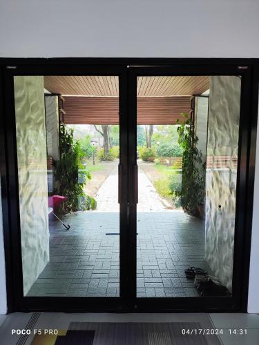 an open door with a view of a patio at Cottage by the pond in Ban Thung Khao Tok