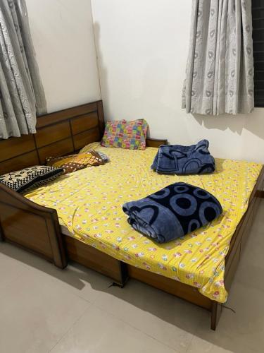 a bedroom with a bed with a yellow bedspread at hotel home stay shiv farm in Gandhinagar